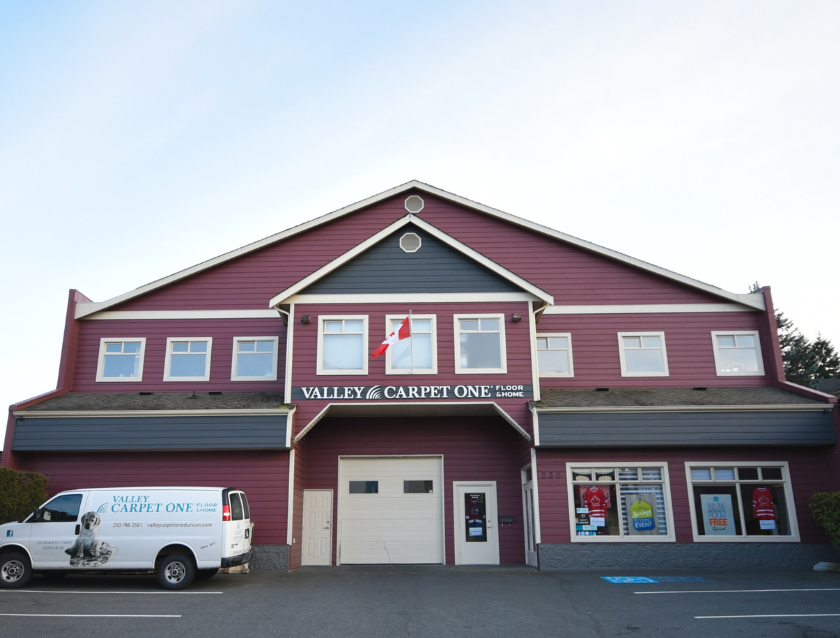 Living room with soft grey and cream furniture and carpet.